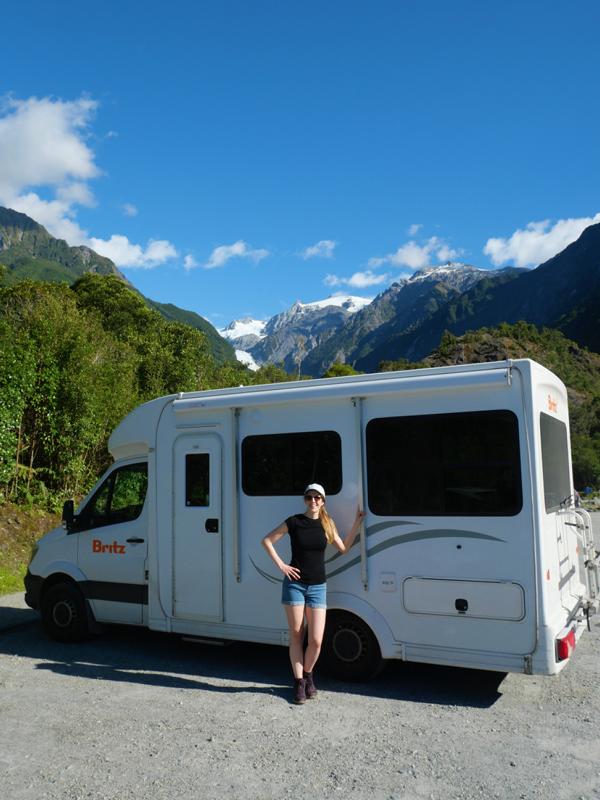 Person und Camper vor Bergen